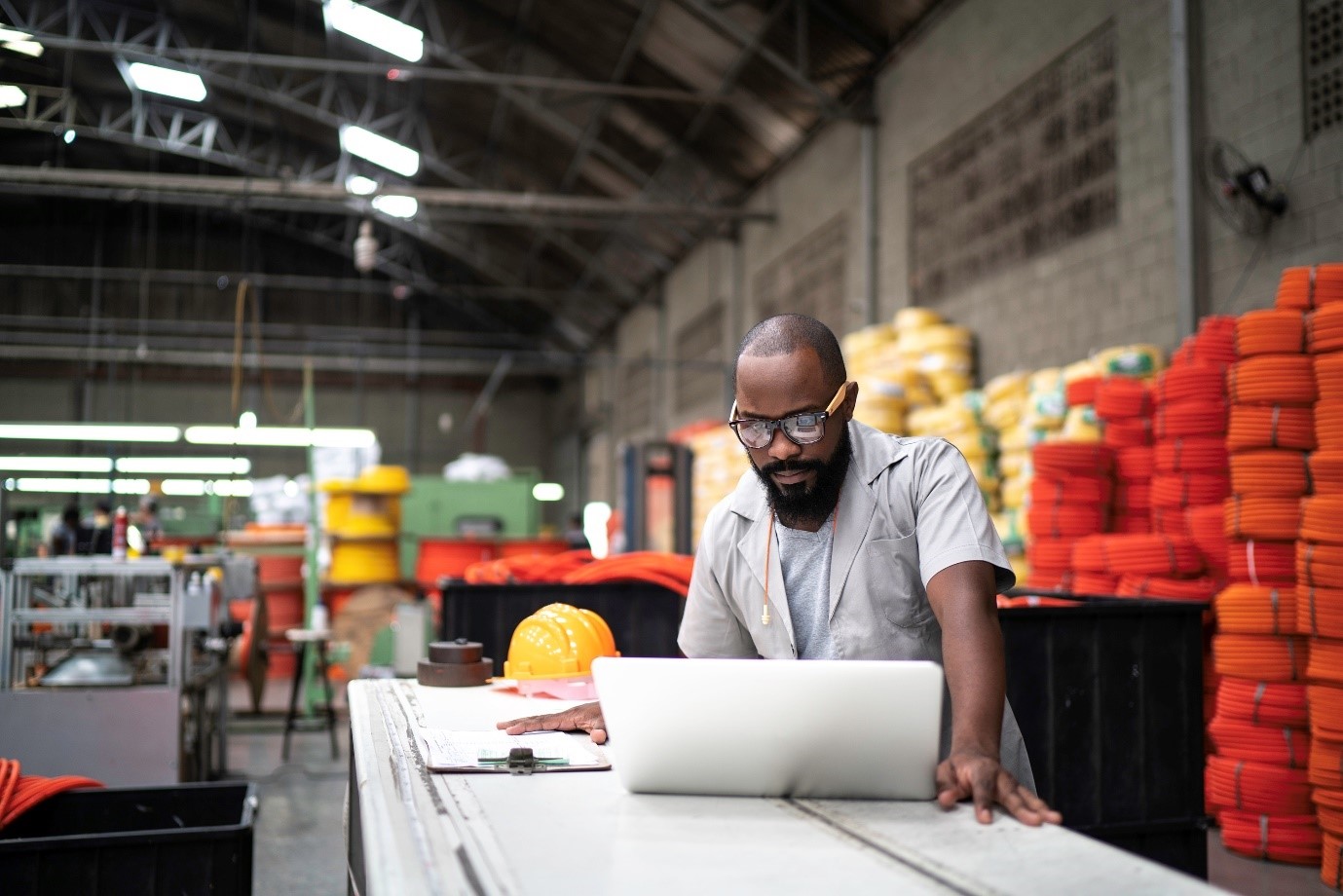 Worker on laptop in warehouse