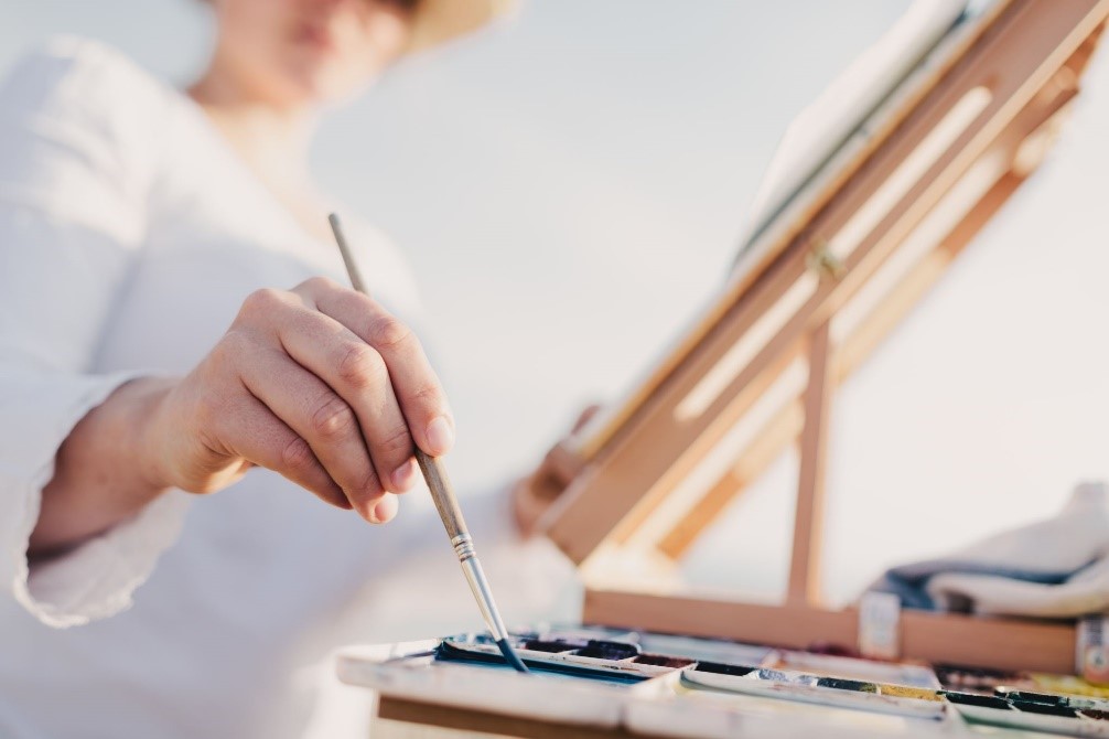 Artist using small paintbrushes