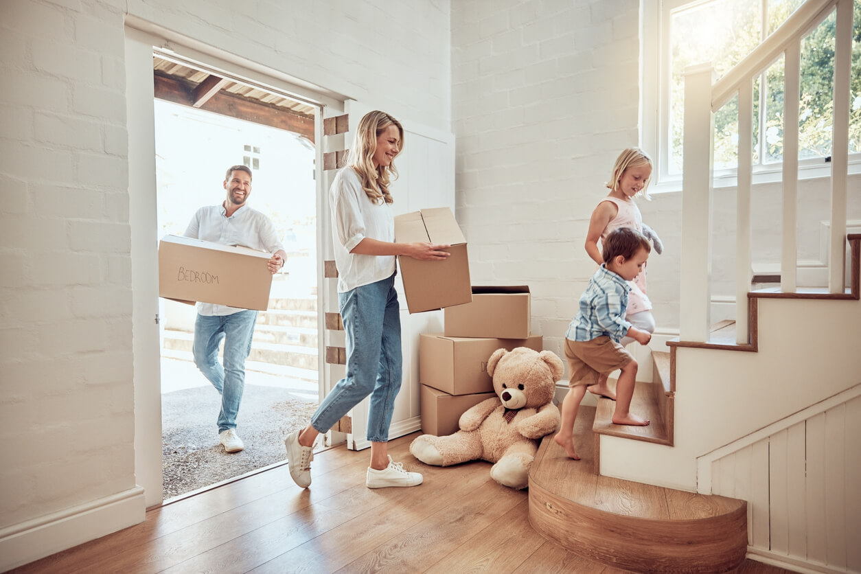 Happy caucasian parents with little kids moving into their new home.