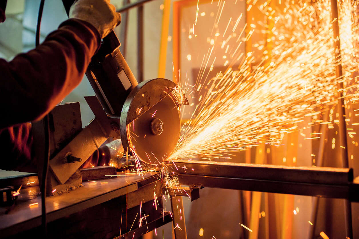 Man working with metal, angle grinding beam.